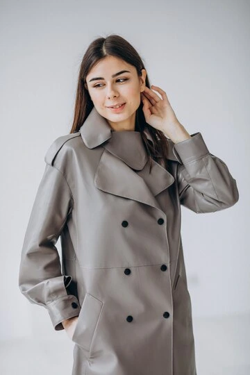 ung kvinnelig modell iført lang grå frakk